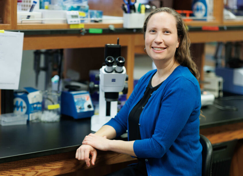 Professor Tessa Solomon-Lane at a desk in science lab